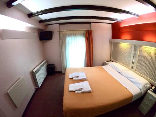 a hotel room with a bed with towels on it at Hotel Micolau in Arinsal