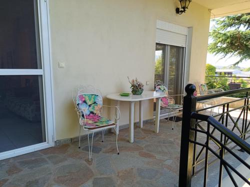 a porch with a table and chairs on a balcony at Dimis apartments in Leptokaria