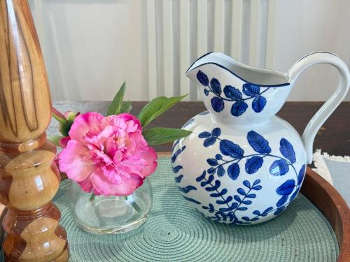a blue and white pitcher and a vase with a pink flower at Zen Escape Guest House " Location 2" - Zen Garden Tiny Home, Nooky Studio, Chillax Rest in Brisbane