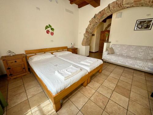 a bedroom with a large bed and a couch at Agriturismo Brusignone in Besana in Brianza