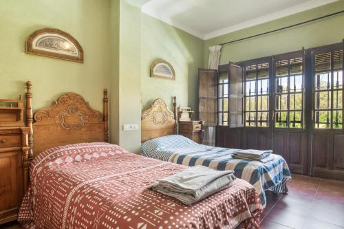 a bedroom with two beds and a window at Casa Rural Cantarrana in Arriate