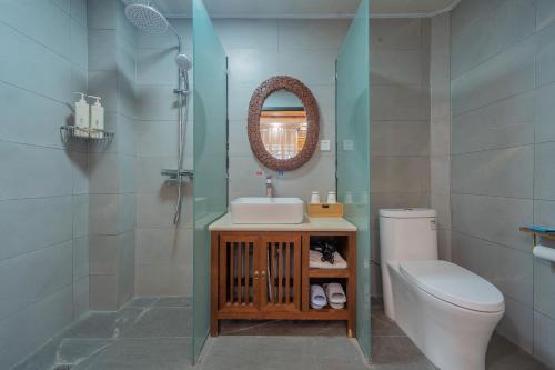 a bathroom with a sink and a toilet and a mirror at Yiyuan Snow Mountain View Historical Naxi House - Lijiang Old Town Mufu branch in Lijiang