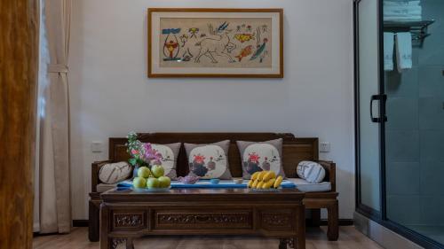 a table with fruit on it in a living room at Yiyuan Snow Mountain View Historical Naxi House - Lijiang Old Town Mufu branch in Lijiang