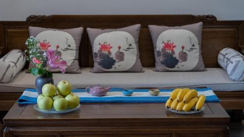 a table with two plates of fruit on it at Yiyuan Snow Mountain View Historical Naxi House - Lijiang Old Town Mufu branch in Lijiang