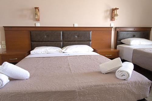 a bedroom with two beds with towels on the bed at Amoudi Studios Apartments Hotel in Amoudi