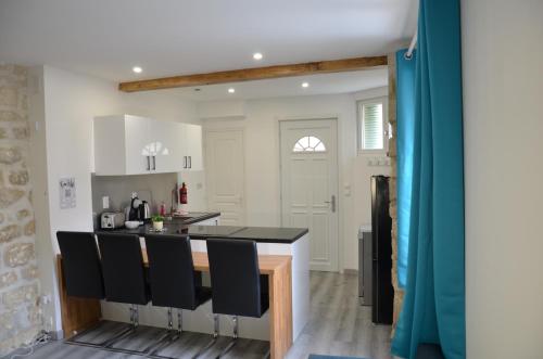 une cuisine avec un comptoir noir et des chaises noires dans l'établissement Spacious house, near Paris, à Houilles