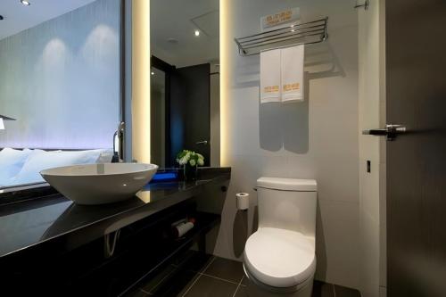 a bathroom with a white toilet and a sink at Jinglai Hotel Changshou Road Subway Station Branch in Shanghai