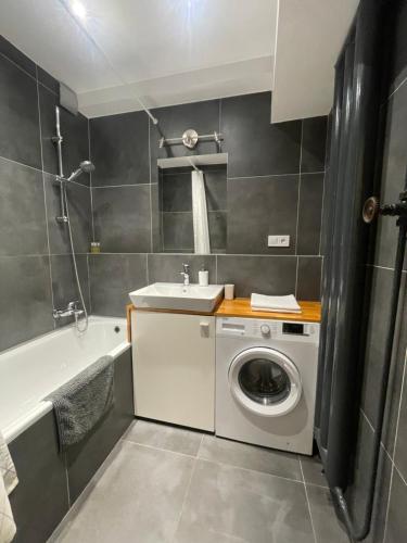 a bathroom with a washing machine and a sink at Cozy Self check-in Apartment in vibrant Ruzinov area, Komárnická 42, Bratislava in Bratislava