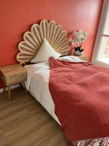 une chambre avec un grand lit avec un mur rouge dans l'établissement Appartement festival avignon, à Avignon