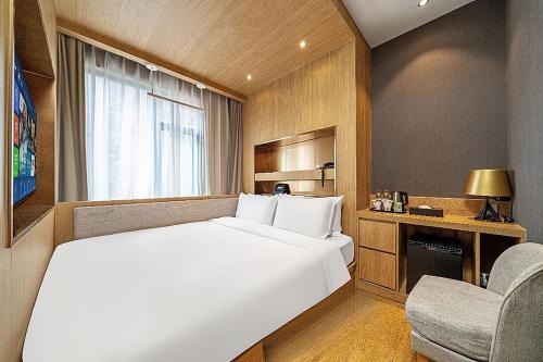 a bedroom with a large white bed and a chair at Jinglai Hotel Changshou Road Subway Station Branch in Shanghai