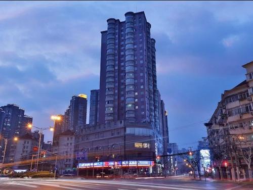 a tall building on a city street at night at Jinglai Hotel Changshou Road Subway Station Branch in Shanghai