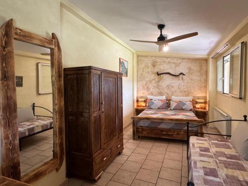 a bedroom with a bed and a large wooden cabinet at Gufo in Pitigliano