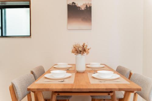 a wooden table with chairs and a vase on it at GLOU Shibuya House - A Private House in Tokyo Shinjuku & Shibuya Area in Tokyo