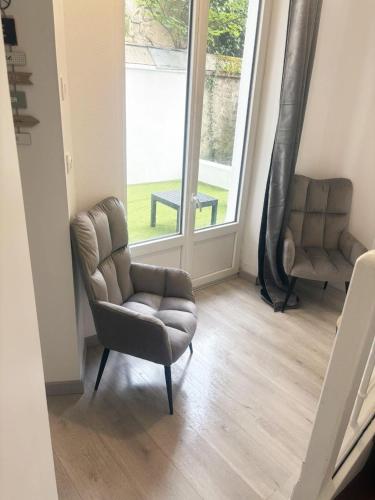 a living room with a chair and a window at Cosy avec spa et sauna et jardin in Boulogne-sur-Mer