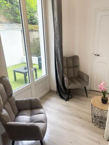 a living room with a couch and a chair at Cosy avec spa et sauna et jardin in Boulogne-sur-Mer