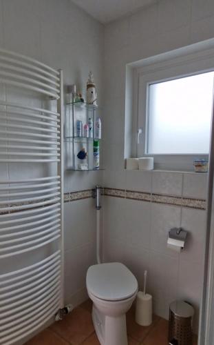 a white bathroom with a toilet and a window at Haus Bernd in Geldern