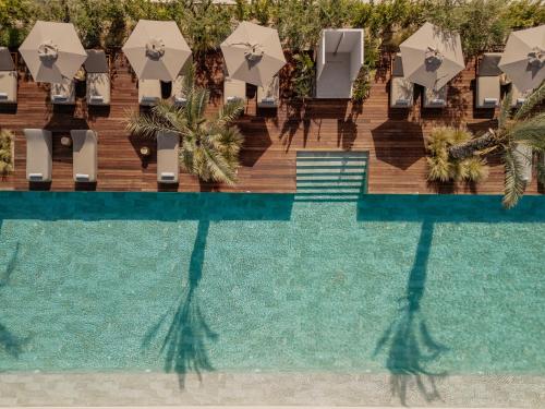 an overhead view of a pool with chairs and umbrellas at Theros All Suite Hotel - Adults Only in Kos Town