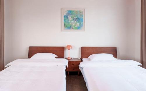 two beds sitting next to each other in a bedroom at Tianmen Mountain Panorama & Cultural Art Exchange Hostel in Zhangjiajie