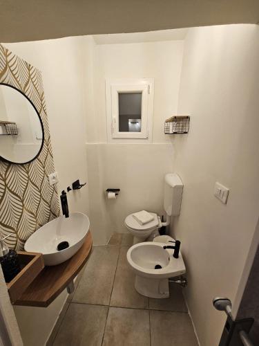 a bathroom with two sinks and a toilet and a mirror at Florence Colonna Spa in Florence