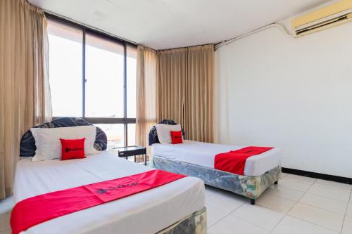 pokój hotelowy z dwoma łóżkami i oknem w obiekcie RedDoorz at Sparkling Hotel Surabaya w mieście Surabaja