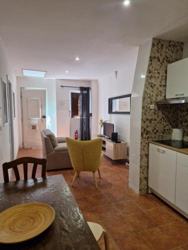 a kitchen and a living room with a couch and a table at Casa do Beco do Chantre I in Évora