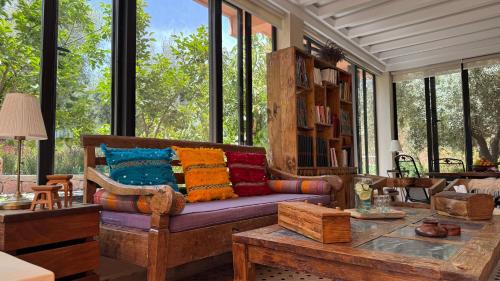 a living room with a couch with colorful pillows on it at Suite - Dar Tidyan Maison d'Hôtes - Ourika Valley in Igzi Ou Fella