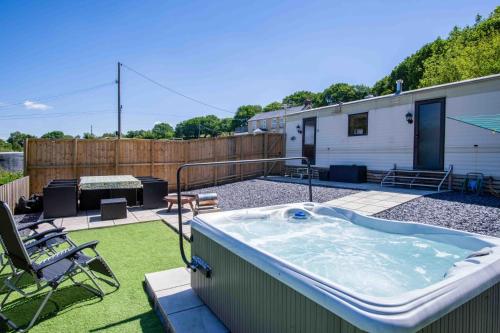 a hot tub in a yard with a patio at Hopkins Retreat - 3 Bedroom Caravan - Hot Tub in Swansea