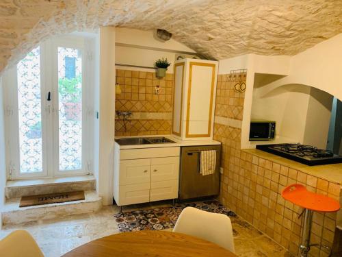 een kleine keuken met een tafel en een raam bij Casa L'Isule in Cisternino