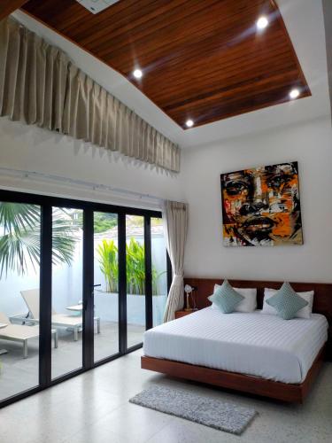 a bedroom with a bed and a large window at Rawai Villa in Rawai Beach