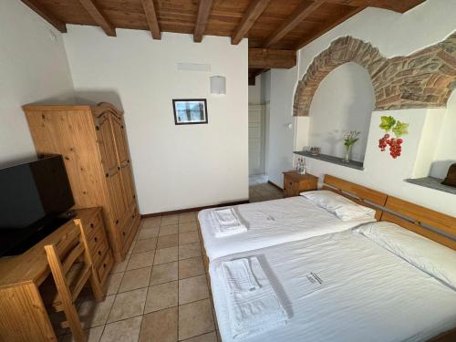 a bedroom with a bed and a flat screen tv at Agriturismo Brusignone in Besana in Brianza