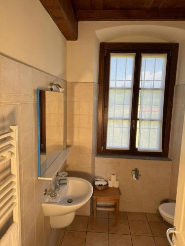 a bathroom with a sink and a toilet and a window at Agriturismo Brusignone in Besana in Brianza