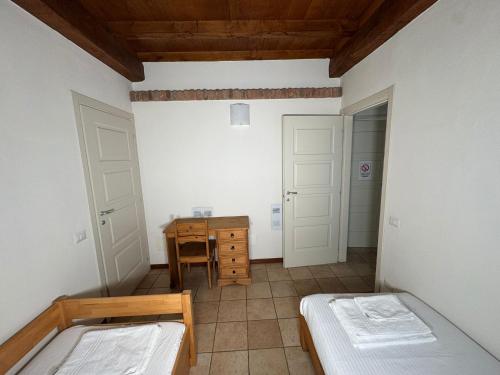 a room with two beds and a table and a desk at Agriturismo Brusignone in Besana in Brianza