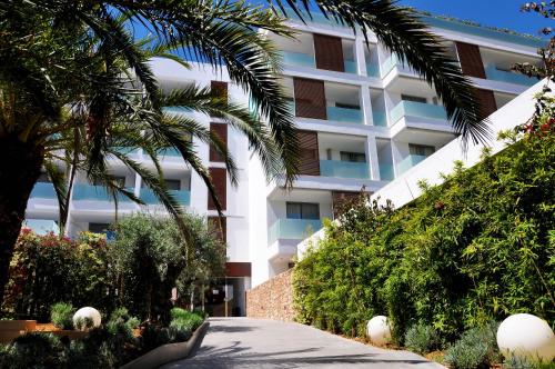 a building with palm trees in front of it at Apartaments B-Llobet Sun & Confort in Ibiza Town