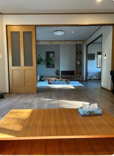 a living room with a wooden door and a table at 伊都山海渓 in Itoshima