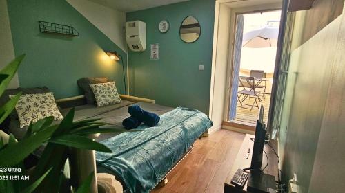 Cette chambre comprend un lit, une télévision et une terrasse. dans l'établissement Au soleil levant*terrasse*Local à vélo*oc keys, à Castelnaudary