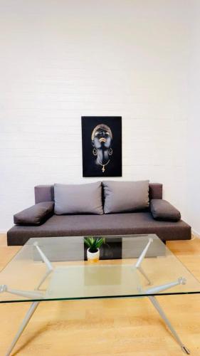a couch with a glass table in a room at Lovely 2BR for 5P Peaceful & Central Stay in Klosterneuburg