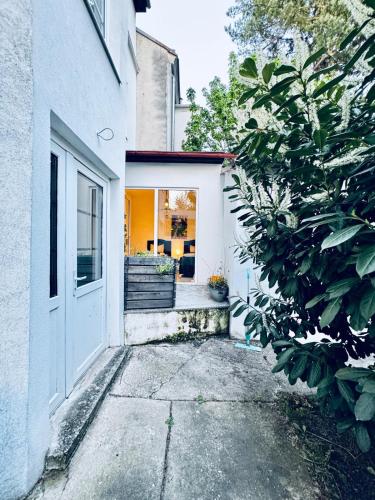 a white house with a door and a porch at Lovely 2BR for 5P Peaceful & Central Stay in Klosterneuburg