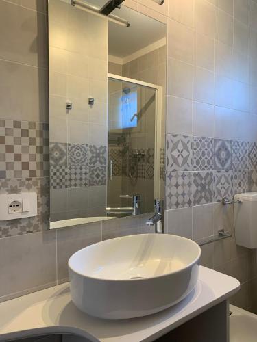 a bathroom with a large white sink and a mirror at Appartamento Oberdan in Milano Marittima