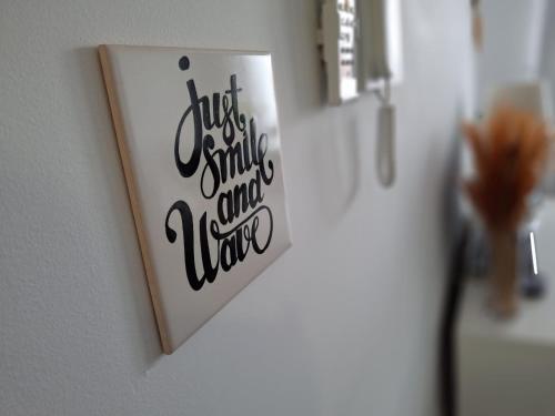 a picture of a bathroom with a sign that says just smile and take at Smile and Wave Apartment in Ponta Delgada