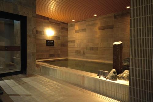 a large swimming pool in a building with at Dormy Inn Higashi Muroran in Muroran