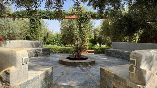 a garden with a fountain in the middle at Dar Tidyan - Maison d'hôtes in Igzi Ou Fella