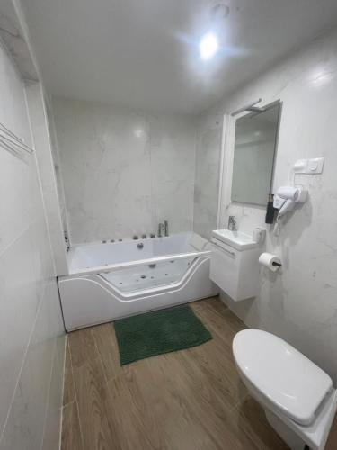 a bathroom with a tub and a toilet and a sink at Hôtel du Parc Canal - Stade de France in Saint-Denis