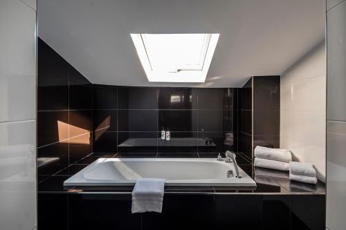La salle de bains est pourvue d'une baignoire et d'une lucarne. dans l'établissement Hôtel Le Canberra, à Cannes