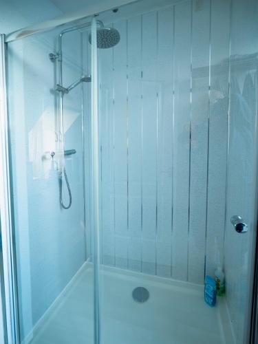 a shower with a glass door in a bathroom at Castle View - Home from Home in Stirling