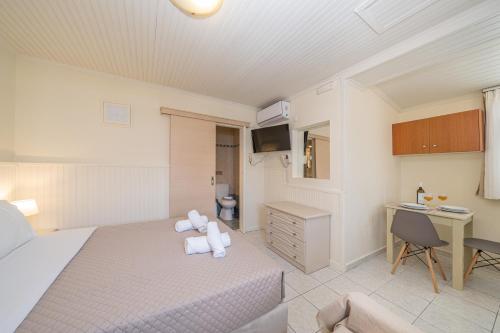 a bedroom with a bed and a desk and a sink at MAKIS VILLAGE-APARTMENTS in Ayia Evfimia