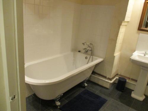 a white bath tub in a bathroom with a sink at Riverside Lodge At Bridge Stores in Great Yarmouth