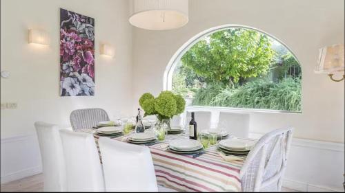 a dining room with a table and chairs and a window at Villa La Memma - Private Villa with Pool for 6 in Case Malva