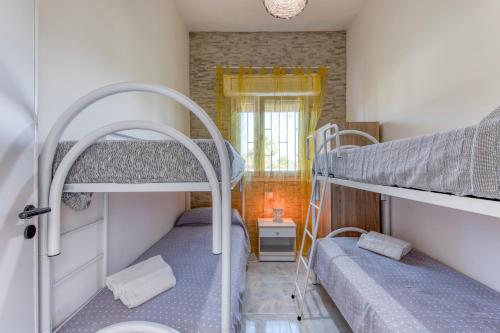 2 literas en una habitación pequeña con ventana en Villetta Marchese, en Salve