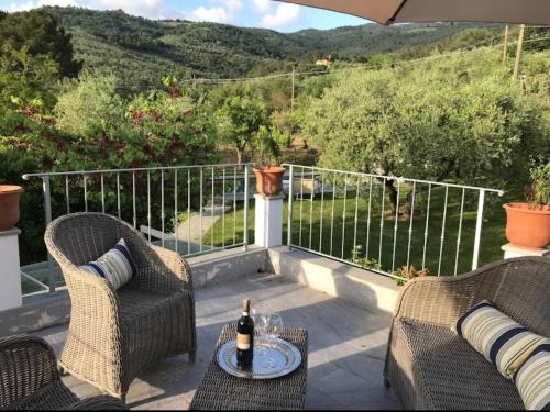 a patio with two chairs and a table with a bottle of wine at Villa La Memma - Private Villa with Pool for 6 in Case Malva