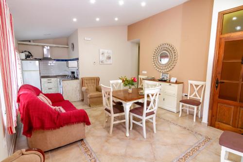 eine Küche und ein Wohnzimmer mit Tisch und Stühlen in der Unterkunft Apartamentos Rurales Tía María in Mata de Alcántara
